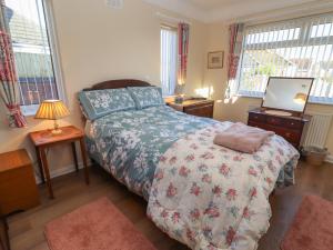 a bedroom with a bed and a tv and windows at 4 Venables Road in Chester