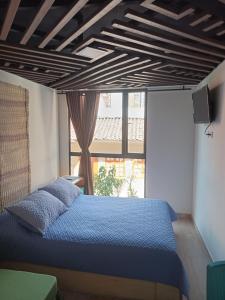 1 dormitorio con cama azul frente a una ventana en Downtown, Blue Green Home, Nature inspired, en Bogotá