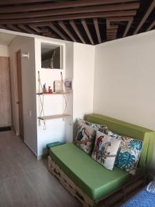 Una habitación con un sofá verde en una habitación. en Downtown, Blue Green Home, Nature inspired, en Bogotá