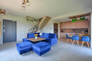 a living room with blue chairs and a table at Szczytowisko in Grywałd