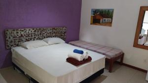 a bedroom with a bed with two towels on it at Geribali Suítes in Búzios
