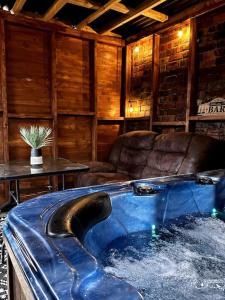 uma grande banheira azul num quarto com um sofá em Modern and spacious house with Hot Tub em Lincolnshire