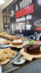 uma mesa com diferentes tipos de bolos e pastelarias em Hotel Boa Viagem em Barra do Garças