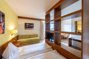 シェーナにあるAndreas Hoferのベッド1台とリビングルームが備わる客室です。