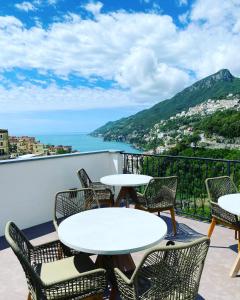 balcone con tavoli, sedie e vista sull'oceano di Calamarina B&B a Vietri