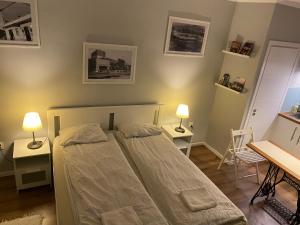 ein Schlafzimmer mit einem Bett, zwei Tischen und zwei Lampen in der Unterkunft B&B Apartman Eger in Eger