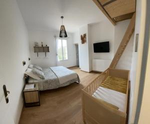 1 dormitorio con 1 cama y TV. en Havre de paix - Chambres d'hôtes en La Sauve-Majeure