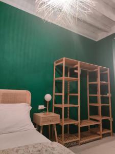 a bedroom with a green wall with a bookcase next to a bed at Residenza Sant'Andrea Smeraldo in Chioggia +11 photos