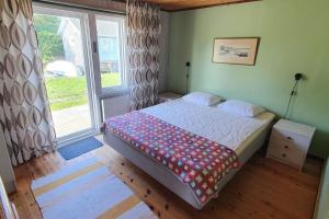 ein Schlafzimmer mit einem Bett und einem großen Fenster in der Unterkunft Gästhus på Fårös savann. in Fårö
