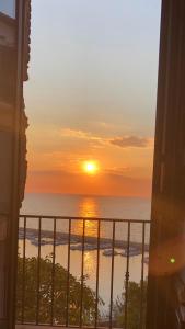 um pôr-do-sol sobre o oceano a partir de uma varanda em Suites Luisa Sanfelice em Agropoli