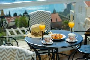 une table bleue avec de la nourriture et deux verres de jus d'orange dans l'établissement Villa Capitano - ap.4, à Mlini