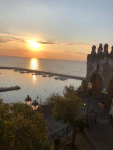 een zonsondergang boven een zwembad naast de oceaan bij Suites Luisa Sanfelice in Agropoli