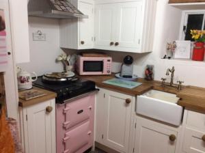 a kitchen with a sink and a microwave at Mermaid Cottage in West Lulworth