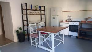 uma cozinha com uma mesa de madeira e um frigorífico branco em Posada San Pedro em Concordia