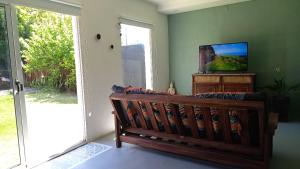 uma sala de estar com um banco de madeira e uma porta de vidro deslizante em Posada San Pedro em Concordia