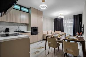 Il comprend une cuisine et un salon avec une table et des chaises. dans l'établissement Airport Apartment - Private Terrace & Parking - by Rentujemy, à Varsovie