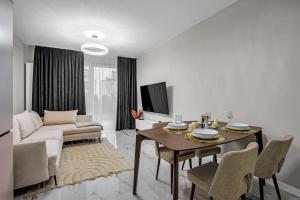 salon ze stołem i kanapą w obiekcie Airport Apartment - Private Terrace & Parking - by Rentujemy w Warszawie