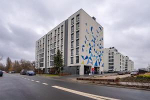 un gran edificio blanco con un patrón azul y blanco en Airport Apartment - Private Terrace & Parking - by Rentujemy en Varsovia