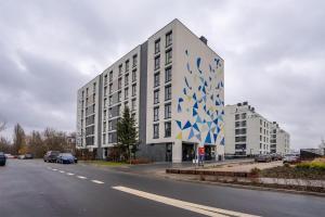 ein großes weißes Gebäude mit einem blauen und weißen Muster darauf in der Unterkunft Airport Apartment - Private Terrace & Parking - by Rentujemy in Warschau