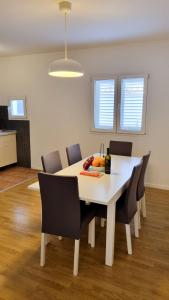 a dining room table and chairs in a room at Villa Neptune Apartments in Vrboska