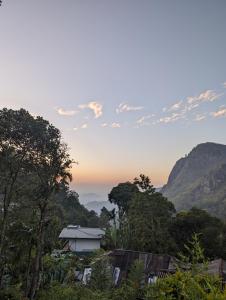 een uitzicht op de bergen met een huis en bomen bij Hive Ella - Hostel in Ella