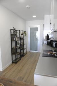 une pièce blanche avec une cuisine avec un plancher en bois dans l'établissement Appartement Penthouse Orihuela costa, à Orihuela Costa