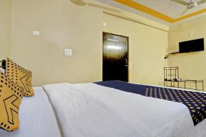 ein Schlafzimmer mit einem großen weißen Bett und einer schwarzen Tür in der Unterkunft Hotel Deep in Jaipur