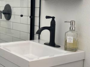 a soap bottle sitting on a sink next to a faucet at Quiet & Peaceful Home Close to LA/Beaches/Disney in Rosemead