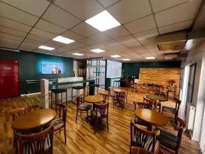 a restaurant with wooden tables and chairs and a bar at Hotel Goya BA in Buenos Aires