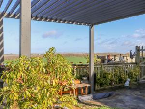 a patio with a pergola with a view of a field at The View in Faversham