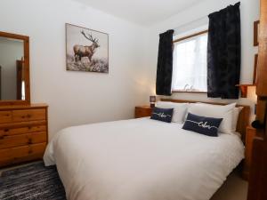 1 dormitorio con 1 cama blanca y una foto de ciervo en la pared en The View, en Faversham