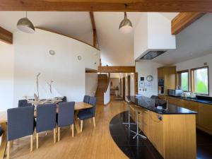 una cucina e una sala da pranzo con tavolo e sedie in legno di Ty Canol a Newborough