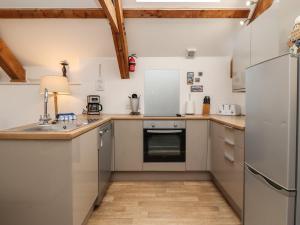 una cocina con electrodomésticos de acero inoxidable y techos de madera. en The Boathouse Seahouses en Seahouses