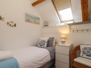 Duas camas num pequeno quarto com uma janela. em The Boathouse Seahouses em Seahouses