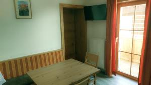 een eetkamer met een houten tafel en een raam bij Ferienwohnungen Lexahaus in Liesing