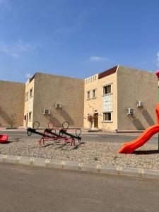 un gruppo di attrezzature per il parco giochi sul lato di una strada di سرايا ان شاليهات وغرف فندقية a Jazan