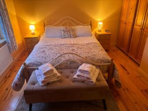 a bedroom with a bed with two towels on it at Tilly's Cottage in Durrus