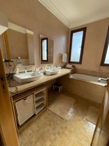 a large bathroom with two sinks and a bath tub at Villa BSF - Private Pool & Spa - Palm Golf in Marrakech