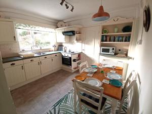 a kitchen with a wooden table with chairs and a dining room at Dubrovnik in Criccieth
