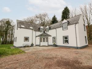 a white house with a gravel driveway at Oakbank in Dumfries