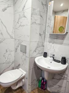 a white bathroom with a sink and a toilet at Boutique Studio B37 in Borovets