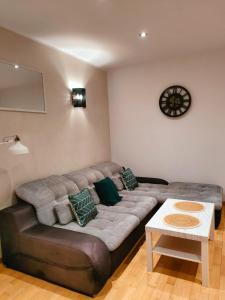 a living room with a large couch and a table at Apartament przy Operze in Białystok