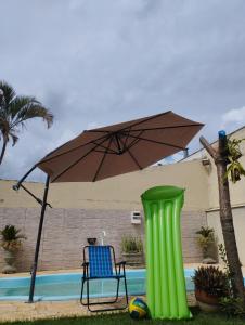 a green object next to a chair and an umbrella at Aero Hostel in Londrina