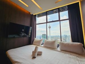 Sky Suites & Residence KLCC Kuala Lumpur في كوالالمبور: سرير في غرفة مع نافذة كبيرة