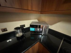 un four micro-ondes installé sur un comptoir dans une cuisine dans l'établissement Rafal Tower two bedroom Apartment, à Riyad