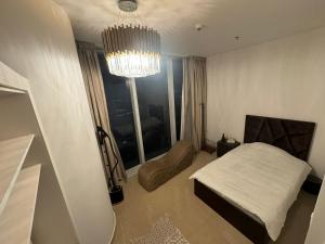 - une chambre avec un lit et un lustre dans l'établissement Rafal Tower two bedroom Apartment, à Riyad
