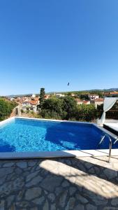 a swimming pool with a chair next to it at Villa Neptune Apartments in Vrboska