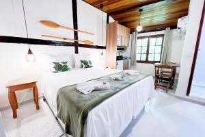 a bedroom with a bed with towels on it at VELINN Pousada Canoa Ilhabela in Ilhabela