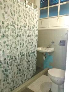 a bathroom with a toilet and a shower curtain at Casa MoraZ Negro in Medellín