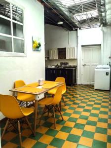 a dining room with a table and yellow chairs at Casa MoraZ Negro in Medellín